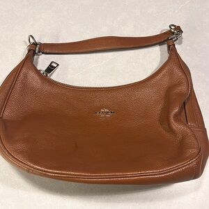 Coach brown leather bag with a short handle.